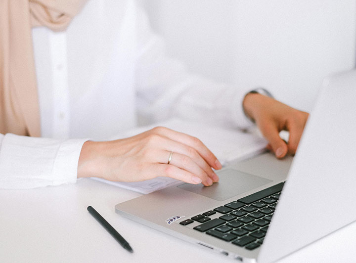 someone typing on a silver laptop