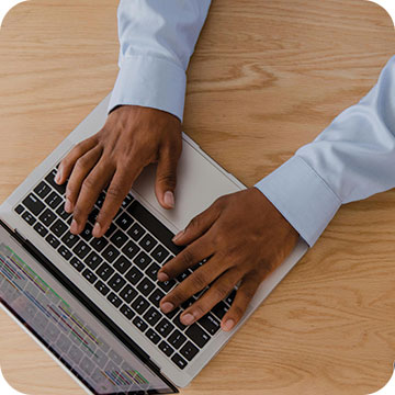 hands typing on silver laptop