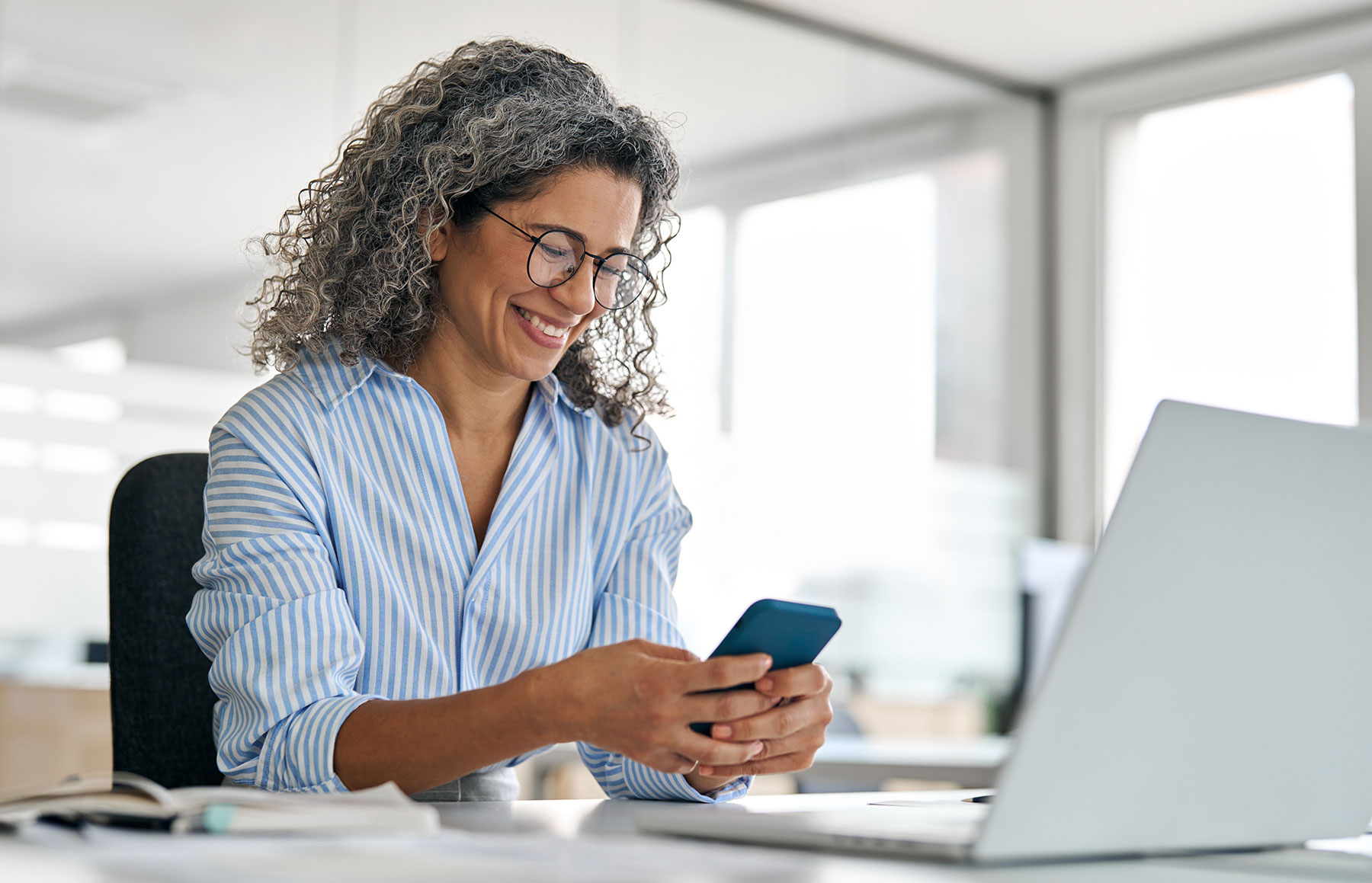 woman looking at phone and smiling