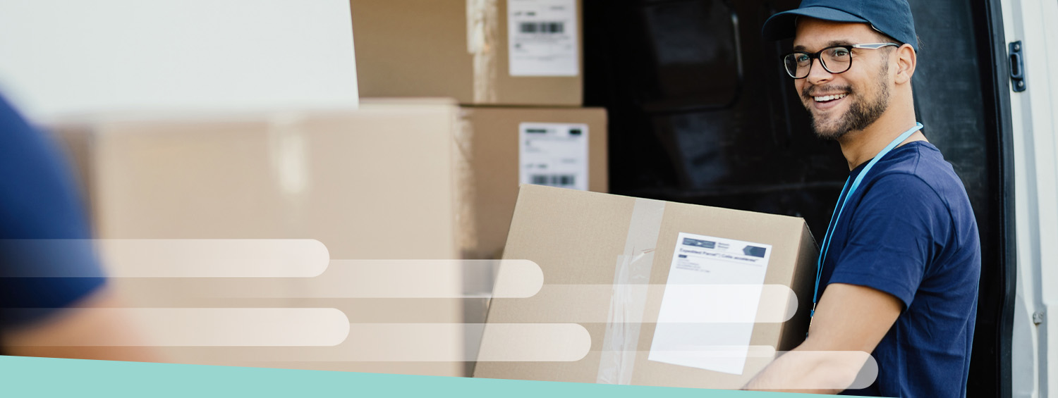 An employee of a moving company transporting moving boxes to the company van