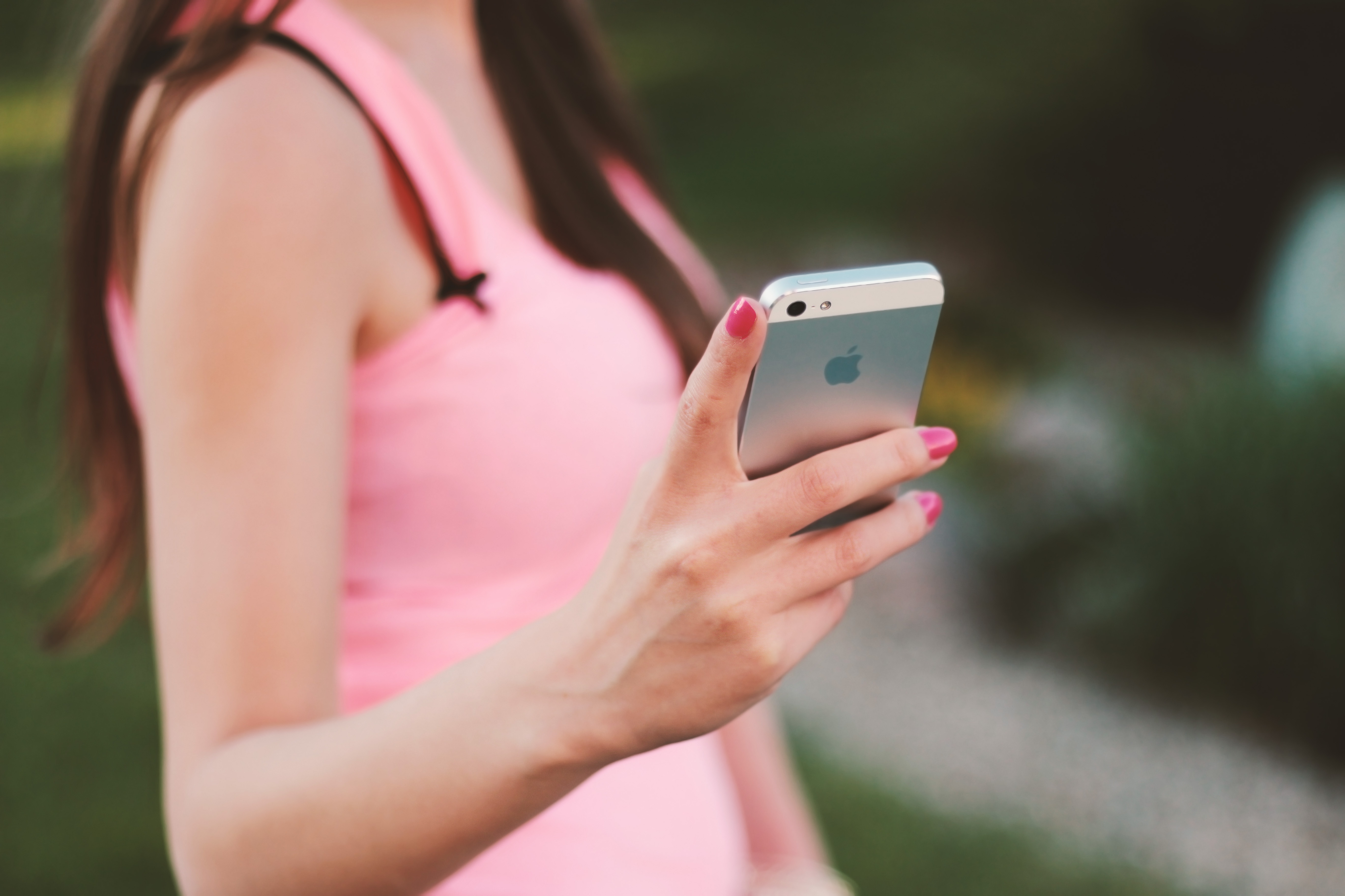 women in pink holding cell phone