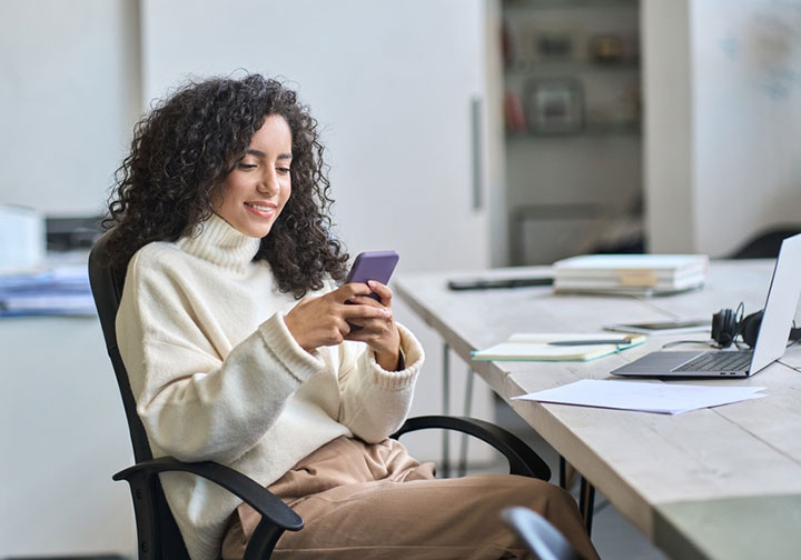 Woman in white sweater looking at her text messages